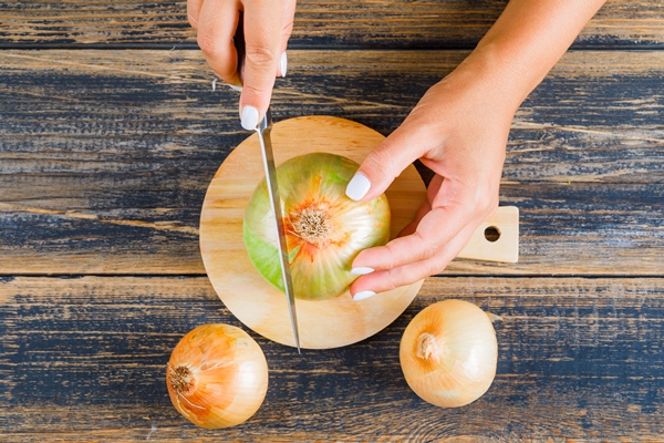woman cutting onion using knife - Салат из белокочанной капусты (школьное питание)