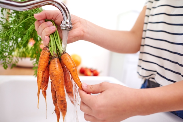 woman washing fresh and organic carrots - Организация правильного питания детей