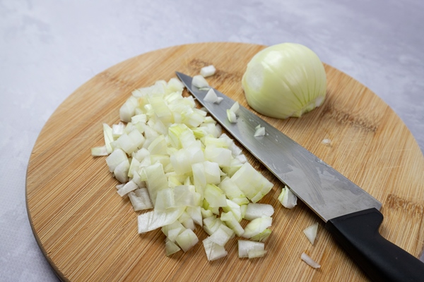 a knife and a knife on a wooden cutting board with onions on it - Винегрет с растительным маслом (школьное питание)