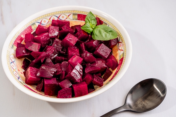 beetroot salad with olive oil and basil in a plate on a white marble background - Винегрет с растительным маслом (школьное питание)