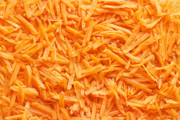 grated carrot close up for backgrounds or textures a close view of finely cut shredded carrot - Салат из белокочанной капусты с морковью и сахаром (школьное питание)