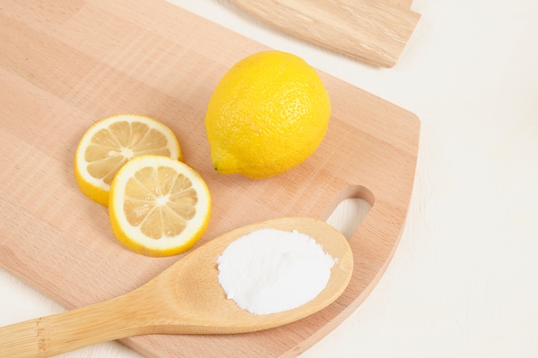lemon and baking soda on wooden spoon knitting board on beige background copy space - Кабачковая икра (школьное питание)