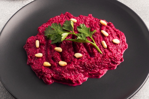 salad of grated beetroot pine nuts and parsley with cream sauce on a plate - Тушёная свёкла со сметаной и ламинарией (школьное питание)