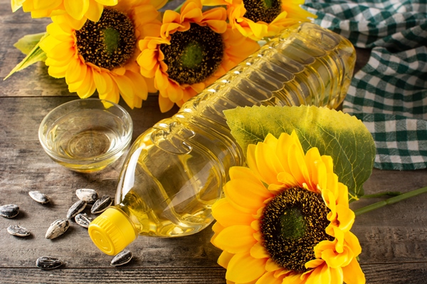 sunflower oil plastic bottle on wooden table 3 - Салат из белокочанной капусты с морковью и яблоками (школьное питание)