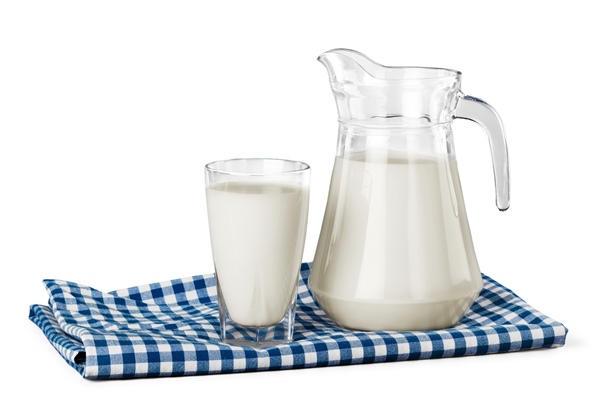 a glass of milk and a milk jug on plaid tablecloth - Пшённая каша молочная вязкая (школьное питание)