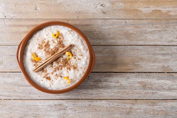 arroz con leche rice pudding with cinnamon in clay bowl on wooden table 1 - Суп молочный с рисом (школьное питание)