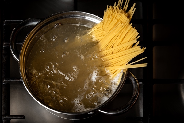 boiling spaghetti in pan on stove in the kitchen - Макароны отварные с сыром (школьное питание)