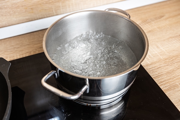 boiling water in a saucepan on an electric stove - Каша "Дружба" (школьное питание)
