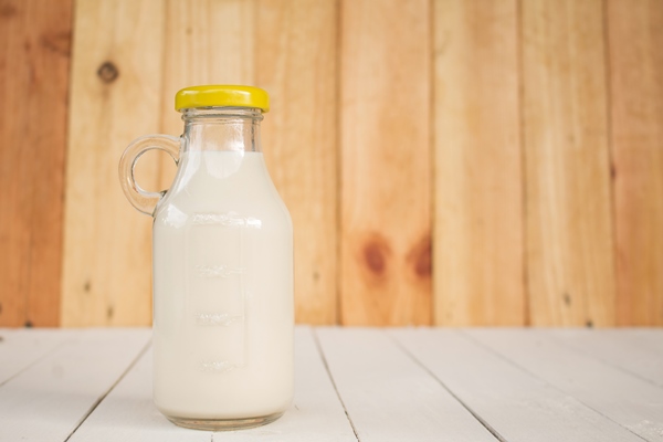 bottle glass of milk on a wooden table - Каша овсяная молочная вязкая (школьное питание)