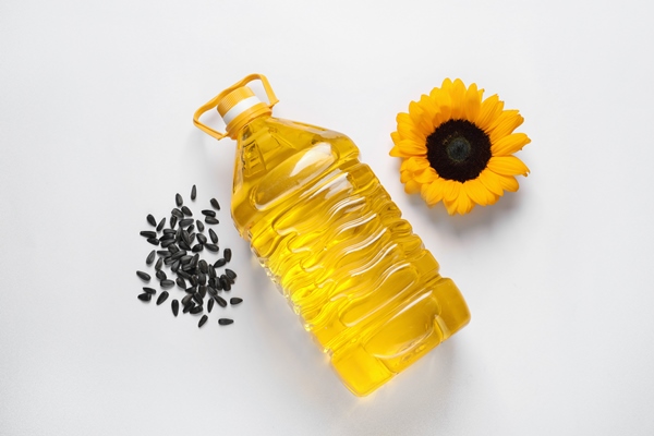 bottle of cooking oil sunflower and seeds on white table flat lay - Суп картофельный с ламинарией и яйцом (школьное питание)