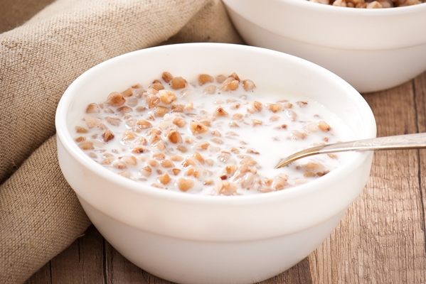 buckwheat porridge in a bowl on a wooden table 1 - Суп молочный с гречневой крупой (школьное питание)
