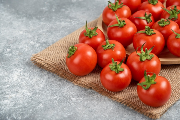 bunch of red fresh tomatoes with sack cloth on marble surface - Постный салат с тунцом "Новогодний"
