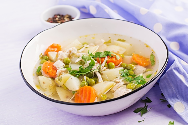 chicken soup with green peas carrots and potatoes in a white bowl - Овощной суп (школьное питание)