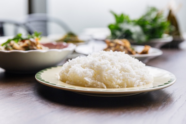 close up steamed rice in a plate served with blur foods background - Рис отварной (школьное питание)