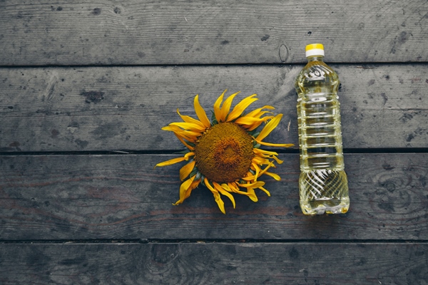 cold pressed oil and a beautiful large blooming sunflower on a wooden background yellow sunflower petals a natural background associated with summer - Рассольник домашний (школьное питание)