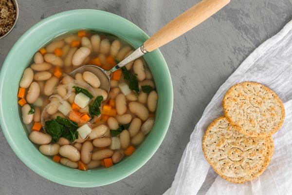 flat lay bowl with white beans soup and crackers - Фасолевый суп (школьное питание)