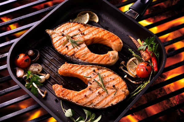 grilled salmon fish with various vegetables on pan on the flaming grill 1 - Стейк из лосося