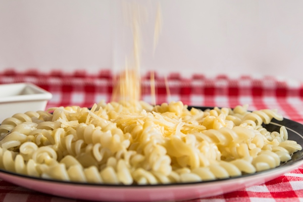 hand sprinkling cheese on pasta - Макароны отварные с сыром (школьное питание)
