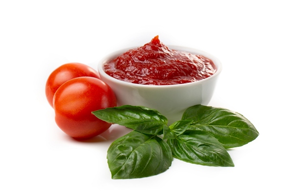 ketchup tomato paste in a saucepan with basil leaves and whole tomatoes on a white background - Тушёная капуста с ламинарией (школьное питание)