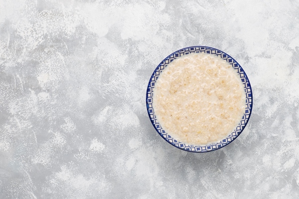 oatmeal porridge in a bowl on concrete top view 1 - Каша жидкая молочная пшеничная (школьное питание)