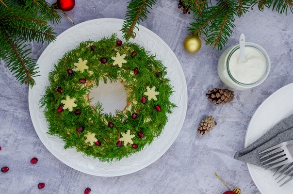 olivier salad christmas wreath with vegetables meat sausage eggs and mayonnaise on a plate on a gray surface - Салат "Рождественский венок"