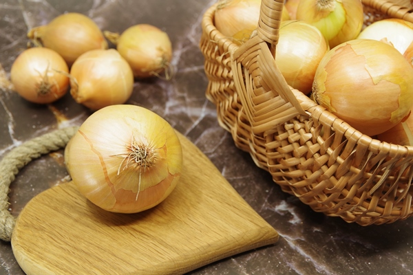 onion on a wooden cutting board - Капуста тушёная (школьное питание)