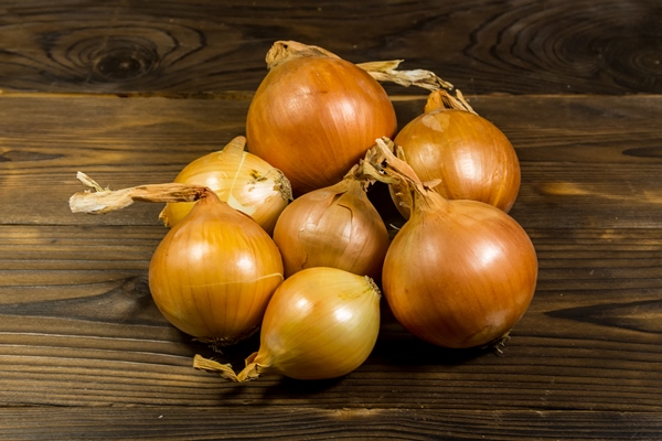 raw golden onion on wooden table - Тушёная капуста с ламинарией (школьное питание)