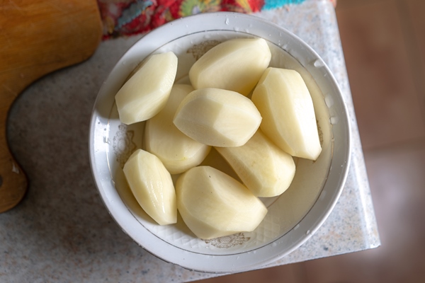 raw washed peeled potatoes in a plate - Свекольник со сметаной (школьное питание)