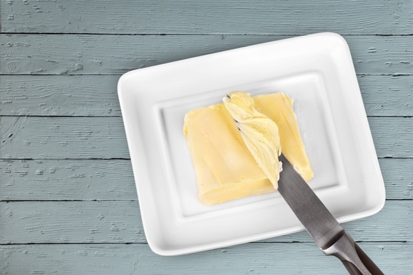 sliced fresh butter curls in white container on wooden table 1 - Каша перловая рассыпчатая (школьное питание)