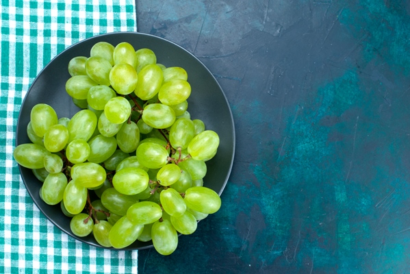 top close view fresh green grapes mellow juicy fruits inside plate on dark blue desk - Закуска "Новогодние ёлочки"