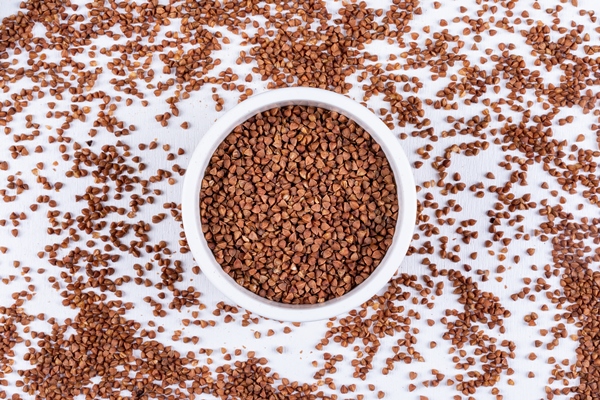 top view buckwheats in bowl and around horizontal - Каша гречневая рассыпчатая (школьное питание)