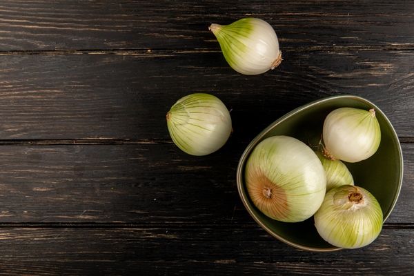 top view of white onions in bowl on wooden background with copy space - Суп рыбный сливочный с горбушей (школьное питание)
