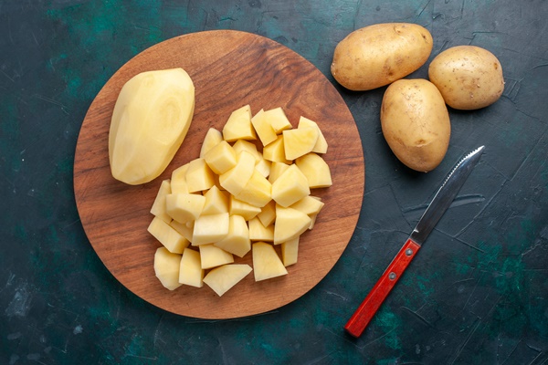 top view sliced fresh potatoes vegetables on dark blue background 2 - Рассольник с рисом (школьное питание)