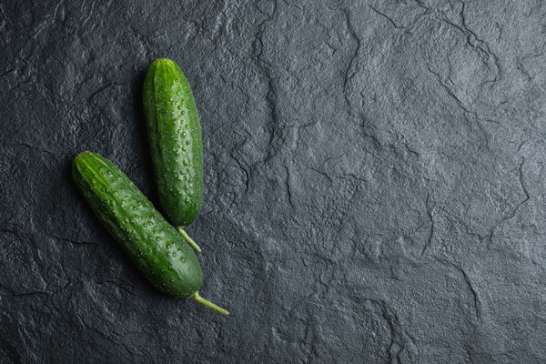 top view two fresh cucumber on black background - Постный салат с тунцом "Новогодний"