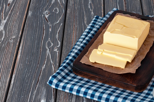 wooden board with butter on blue checkered napkin - Макароны отварные с овощами (школьное питание)