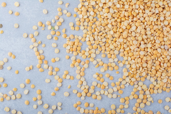 yellow lentil messily scattered over marble background - Гороховый суп (школьное питание)