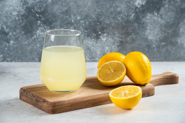 a glass cup of fresh lemon juice on a wooden board - Постный майонез на аквафабе