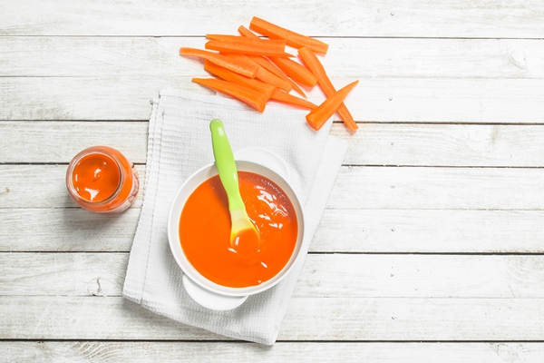 baby food baby puree from fresh carrots with a spoon on a white wooden background - Бефстроганов из отварной говядины (школьное питание)