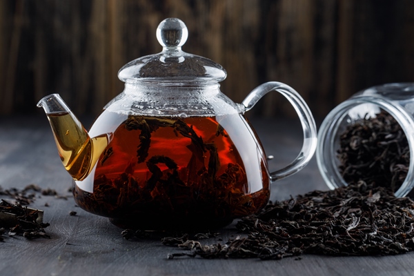 black tea with dry tea in a teapot on wooden surface side view - Чай фруктовый с вишней, малиной и яблоками (диетическое школьное питание)