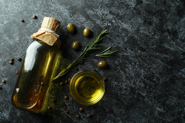 bottle and bowl with olive oil and spices on black smokey surface - Плов с тунцом
