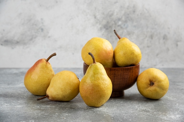 bunch of fresh bio pears in wooden bowl on marble surface - Чай с грушей и апельсином (диетическое школьное питание)