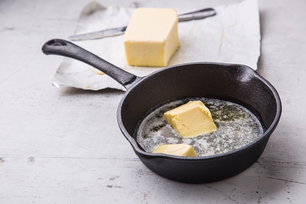 butter pieces of butter in the hot pan top view - Кулинарные традиции празднования Крещения Господня: вареники с картофелем, сыром и яйцом