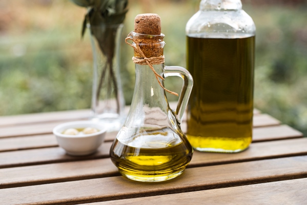 close up bottles of natural olive oil - Постные манные оладьи