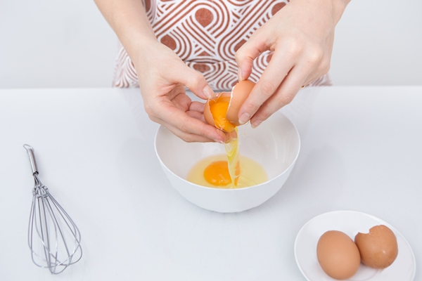 close up of female chef cracking egg - Морковный торт