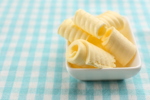 curls of fresh butter in bowl on blue tablecloth - Котлета рыбная любительская (школьное питание)