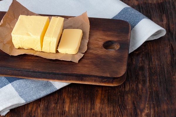 cut butter on plate with blue towel on kitchen table - Запеканка из творога (школьное питание)