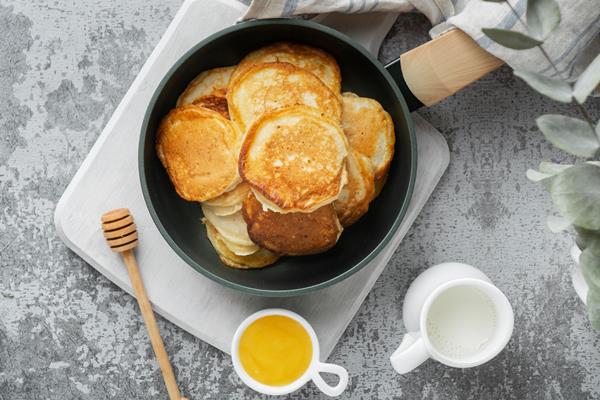 flat lay delicious pancakes and honey - Постные манные оладьи
