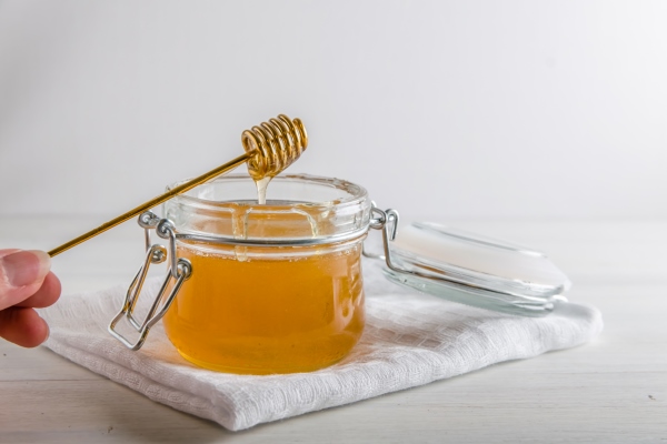 fresh honey drains from spoonfuls for honey with a copy space - Компот из облепихи с мёдом (школьное питание)