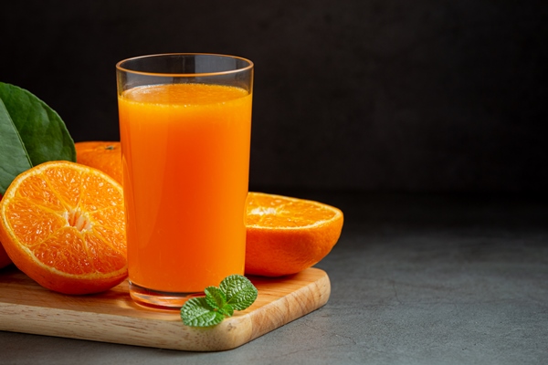 fresh orange juice in the glass on dark background - Апельсиновый напиток (школьное питание)