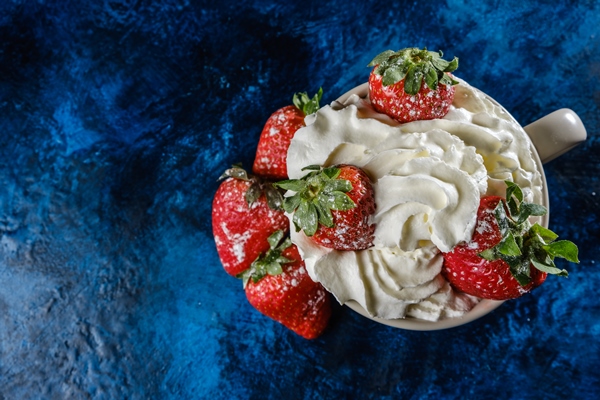 fresh strawberries on a blue textured base - Взбитые сливки без сахара